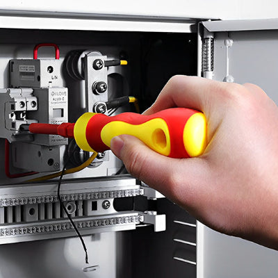 tournevis pour electricien homme qui intervient dans armoire électrique